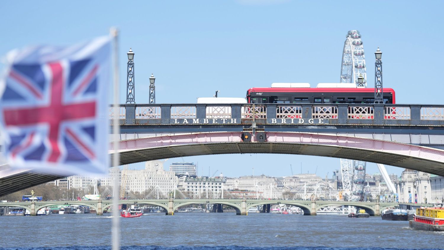 London cityscape with Union Jack flag and bridge over Thames River.