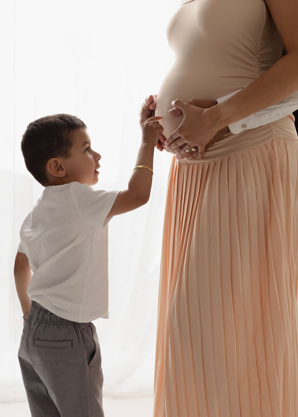son pokes moms belly maternity pose Elizabeth Lang Photography Surrey.