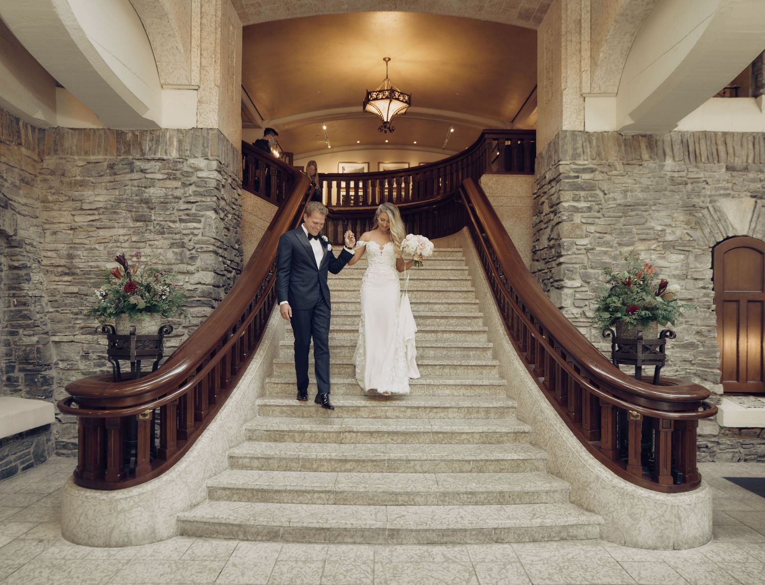 Elegant wood and stone grand staircase with handrails at the Fairmont Banff Springs Hotel. Banff wedding photography