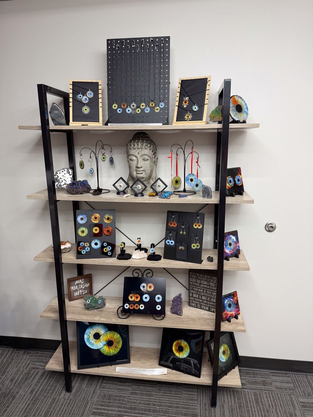 Modern wooden shelving unit displaying artistic cassette tape wall art and Buddha sculpture with decorative CD crafts on multiple tiers.