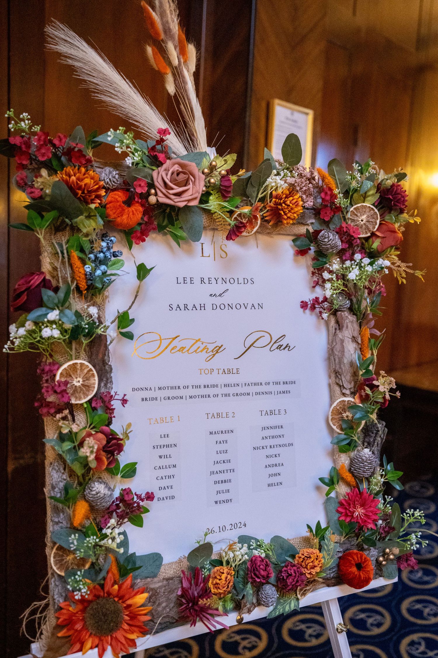 ornate orange autumn themed wedding seating plan on a white easel. Stuart Morris Photography Liverpool wedding photographer.