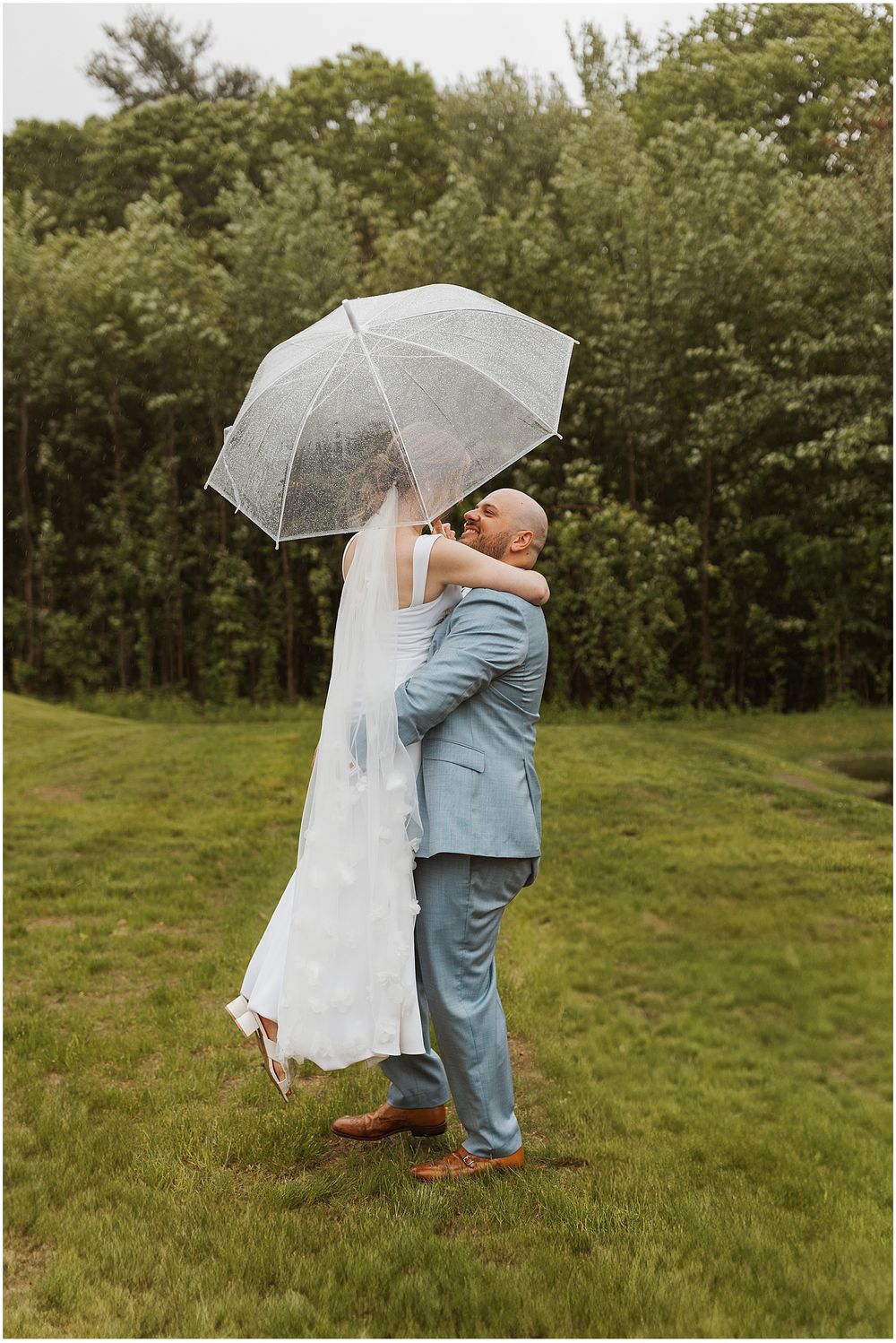 Bride and groom taking rainy portrait photos at NH wedding