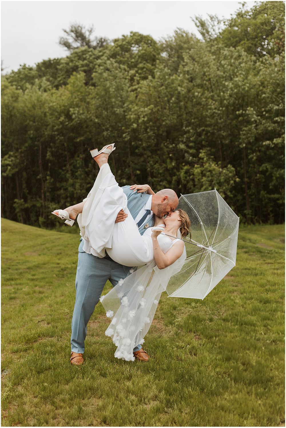 Bride and groom taking portraits in the rain at their New Hampshire wedding
