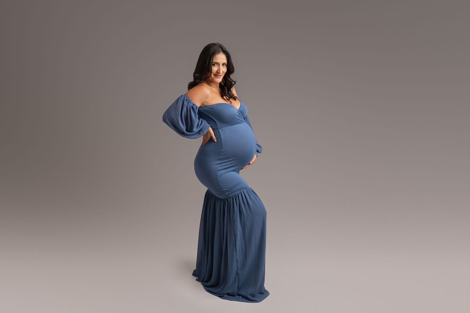 pregnant woman wearing blue form fitting maternity dress during maternity photoshoot in tampa