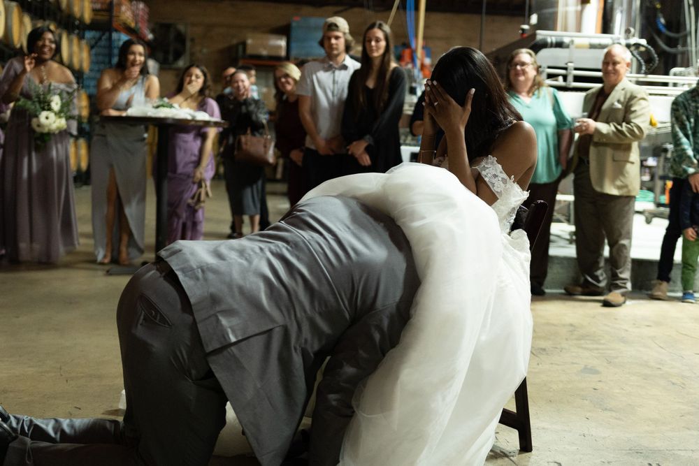 A wedding couple sharing a romantic dip on the dance floor surrounded by guests.