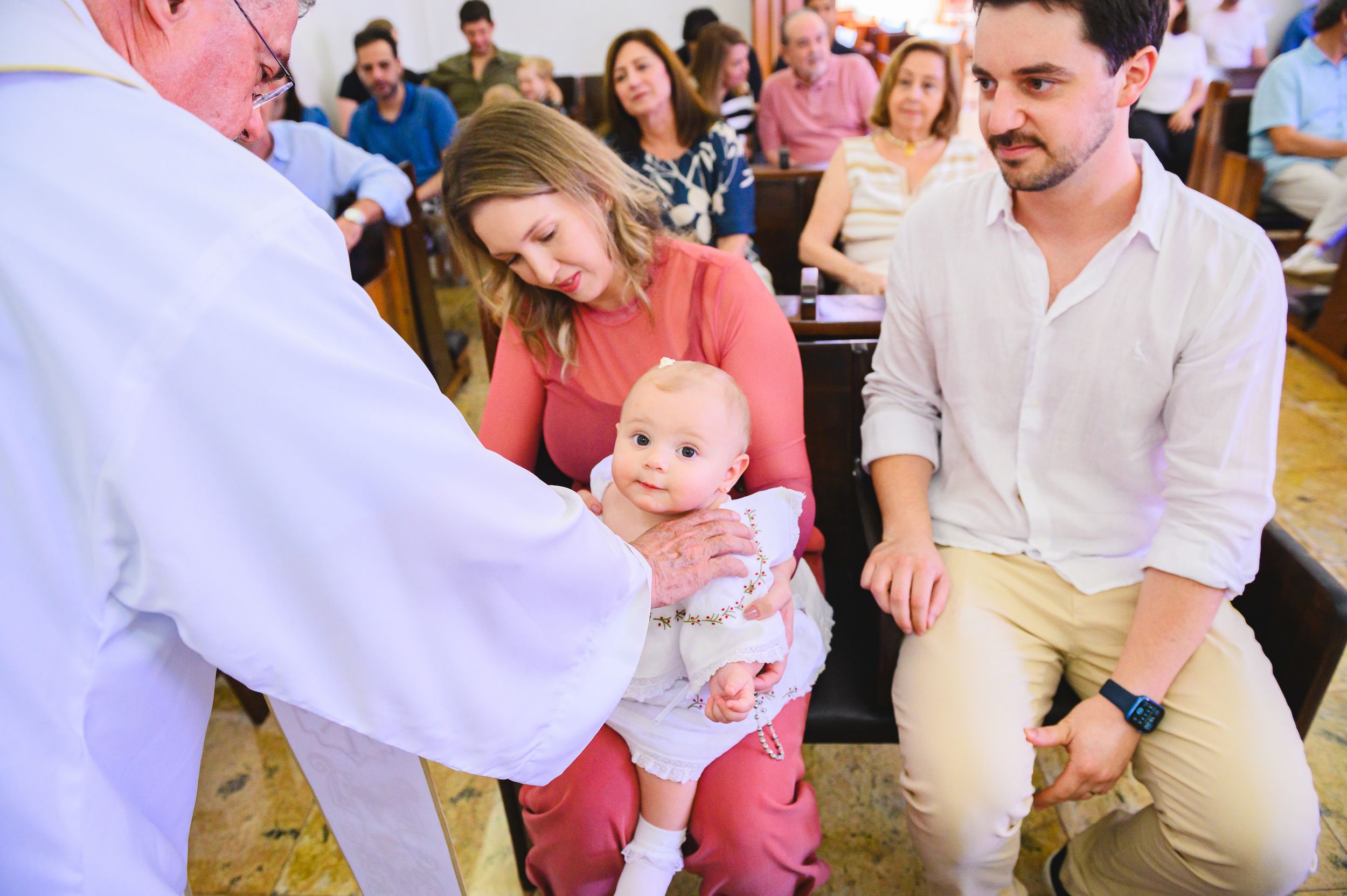 Healthcare provider examining an infant patient during a medical visit as others look on in a waiting room setting.