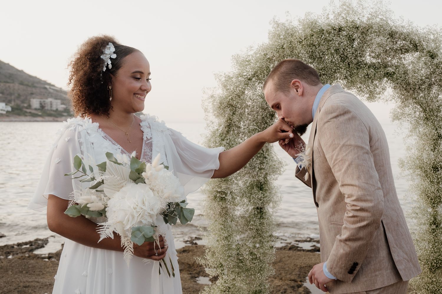 A candid photo of a bride and groom getting married on the beach in Athens riviera Greece