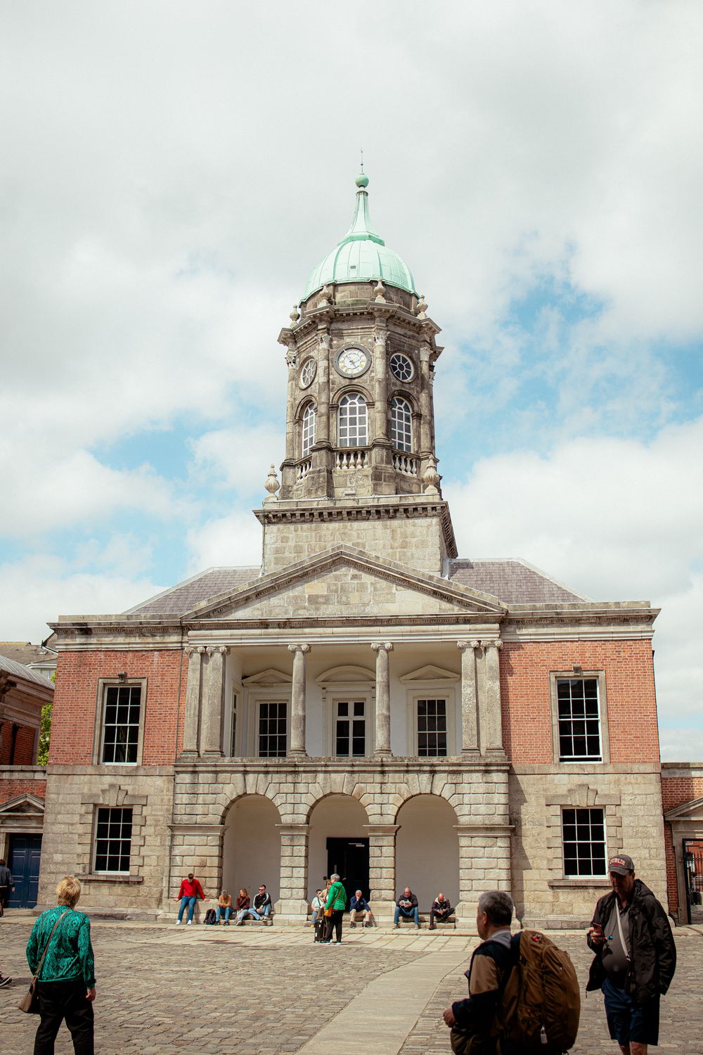 Historic Dublin Castle's Chapel Royal features a distinctive clock tower and copper dome against cloudy Irish skies.