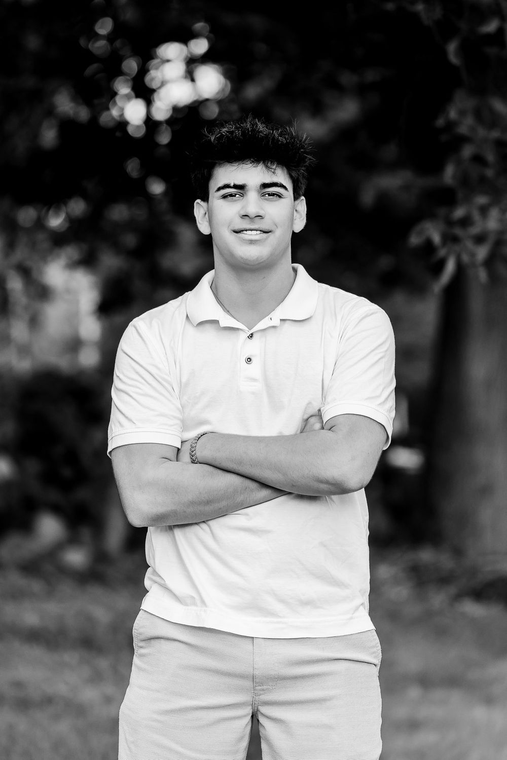 A black and white artistic photo series showing the same child posing with crossed arms in white polo shirt.
