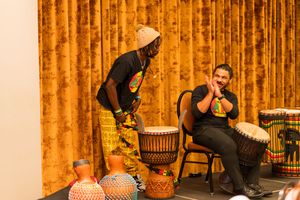 Traditional African drums positioned on stands during a performance setup.