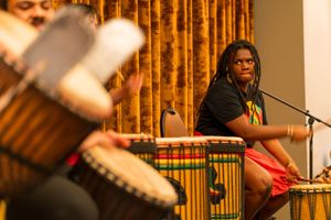 Musicians perform with traditional drums and instruments on stage.