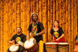 Musicians playing traditional African drums during performance on stage.
