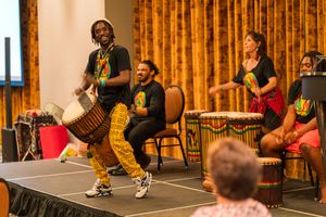 Group performs African drumming and dancing on elevated stage.