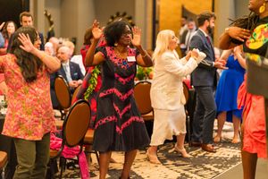 Group of people dancing and celebrating at a lively indoor event.