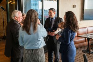 Professional gathering in an office space with large windows and city views.