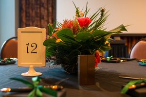Elegant table setting with a vibrant floral centerpiece and table number 12 for an upscale event.
