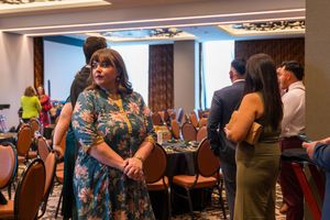 Conference attendees mingle and socialize in a hotel meeting space.