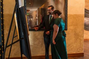 Couple looking at display screen in dimly lit upscale venue hallway.