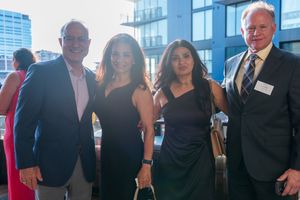 Business professionals mingle and network at a formal corporate event in a modern office setting.