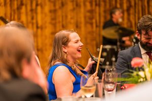 Attendees engaged in lively conversation at a corporate function with warm ambient lighting.