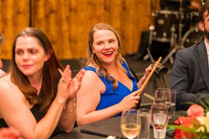 Guests enjoying conversation at an elegant evening banquet with warm lighting.
