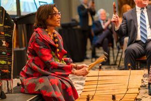Musicians perform traditional music with wooden instruments at cultural event.