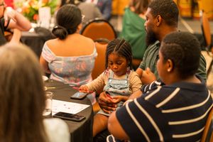 Group of attendees participate in a professional development workshop around tables.