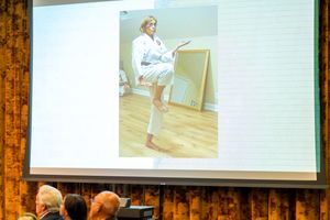 Presentation screen showing images in a room with wood-paneled walls.