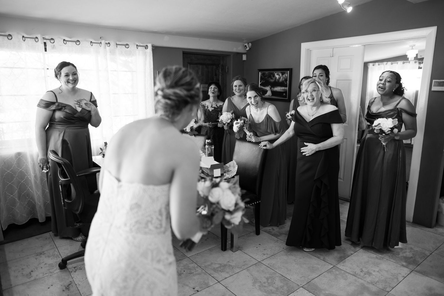 Wedding party gathered in a room sharing an emotional moment before the ceremony.