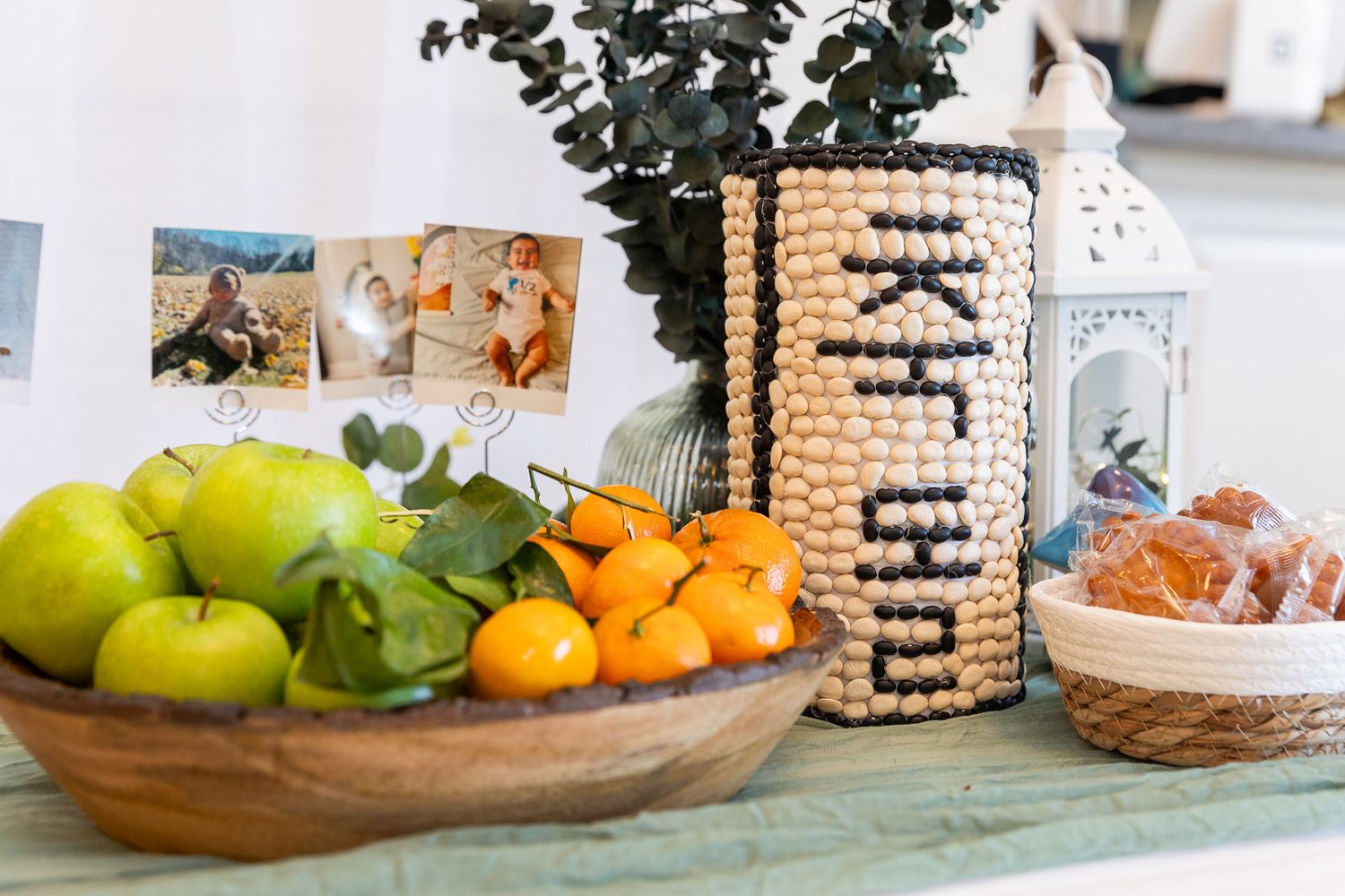 Wooden bowl of fresh citrus fruits with apples sits beside decorative cork holder and small basket on rustic table surface.