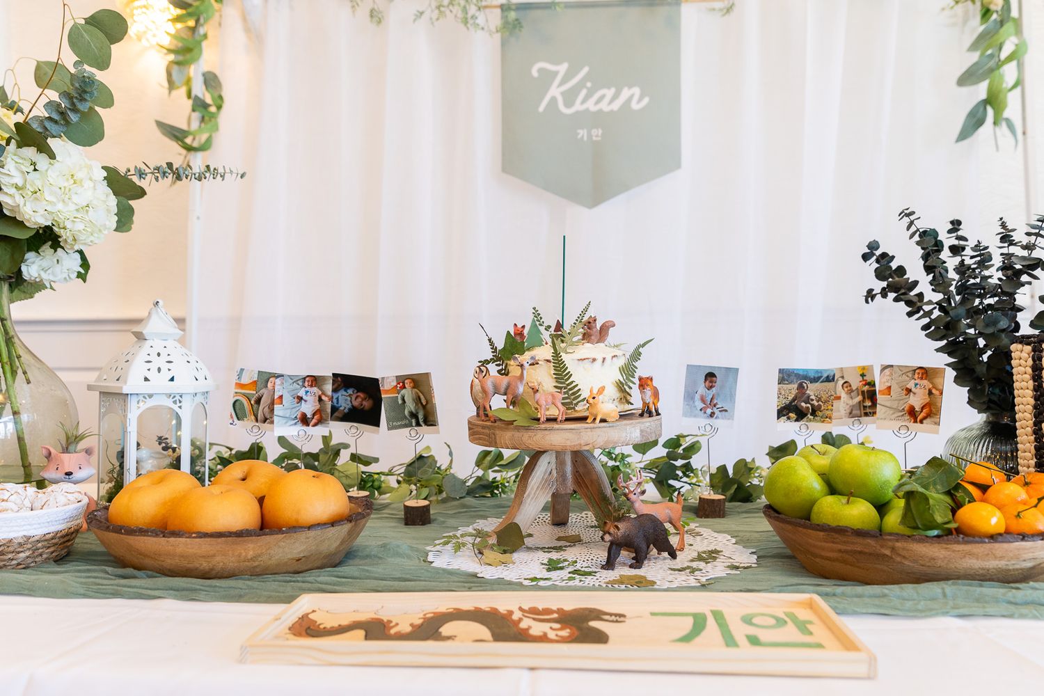 A wedding dessert table decorated with fresh citrus fruits, eucalyptus greenery, and a vintage tiered cake stand.