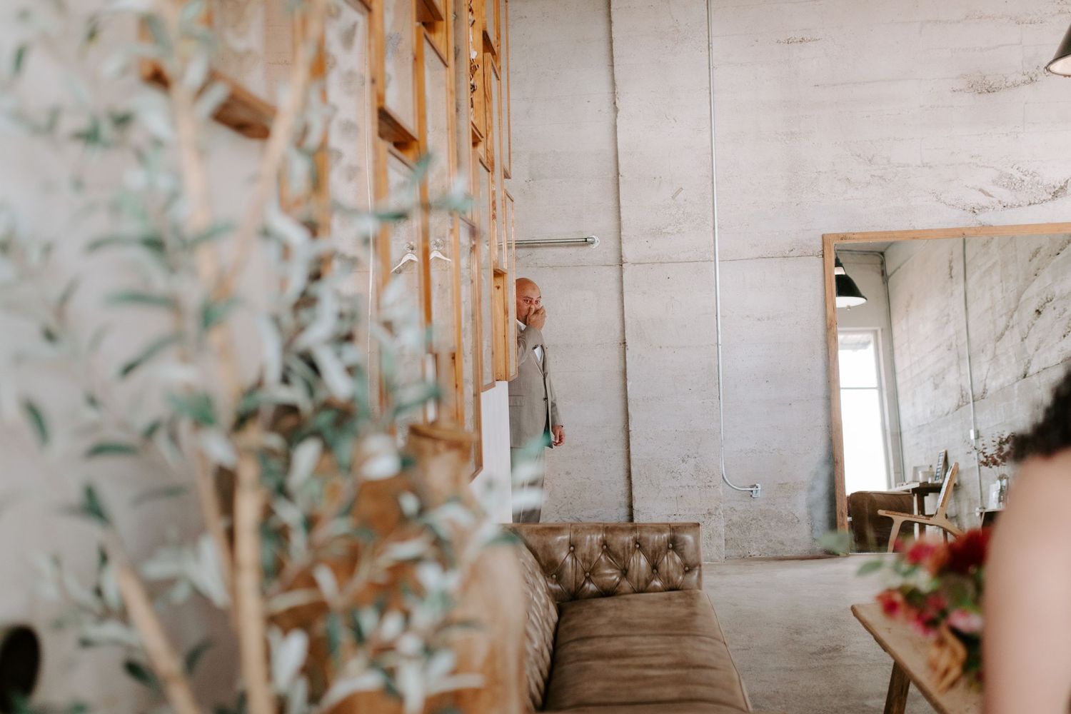 Industrial-style wedding venue interior with butterfly artwork and tufted furniture.