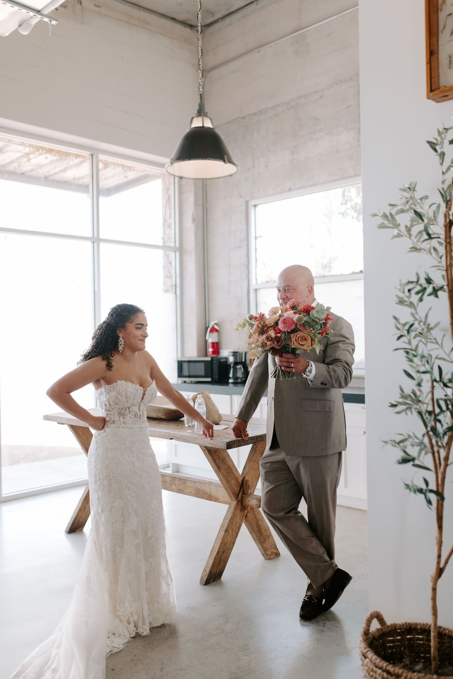 A playful wedding photo with the couple posing casually against industrial decor.