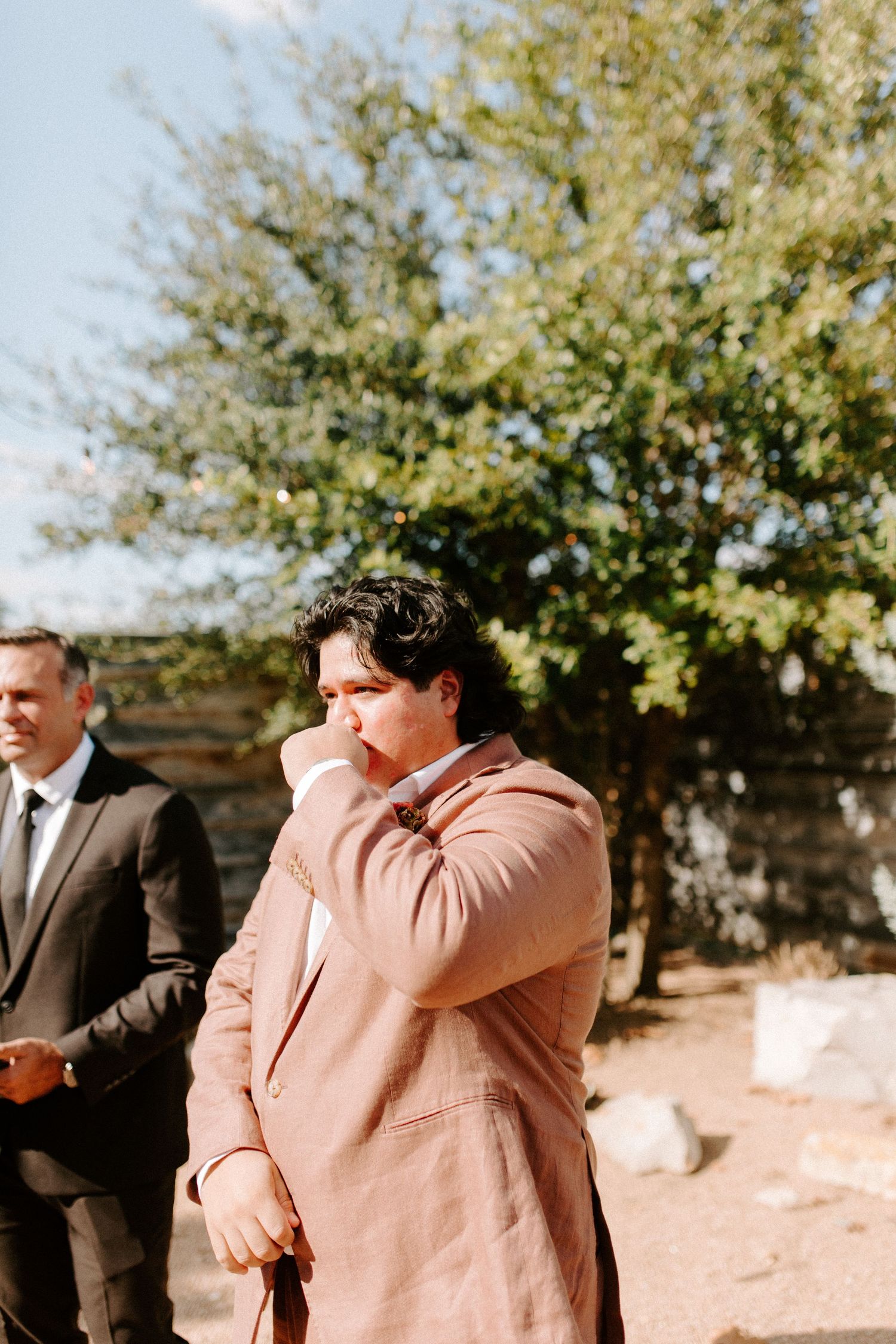 An emotional wedding moment captured during an outdoor ceremony under autumn trees.