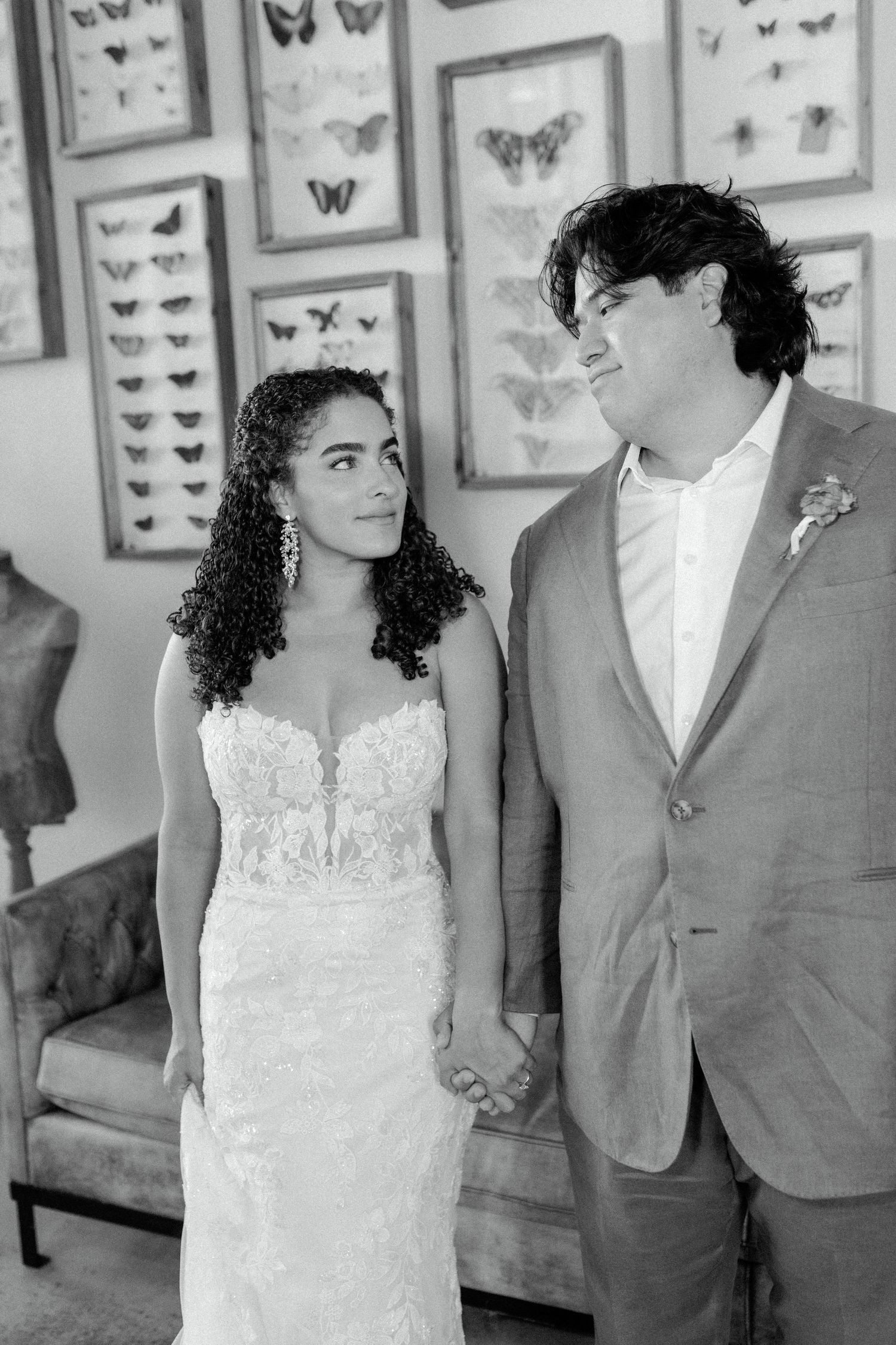 A black and white wedding portrait with butterfly artwork decorating the background.
