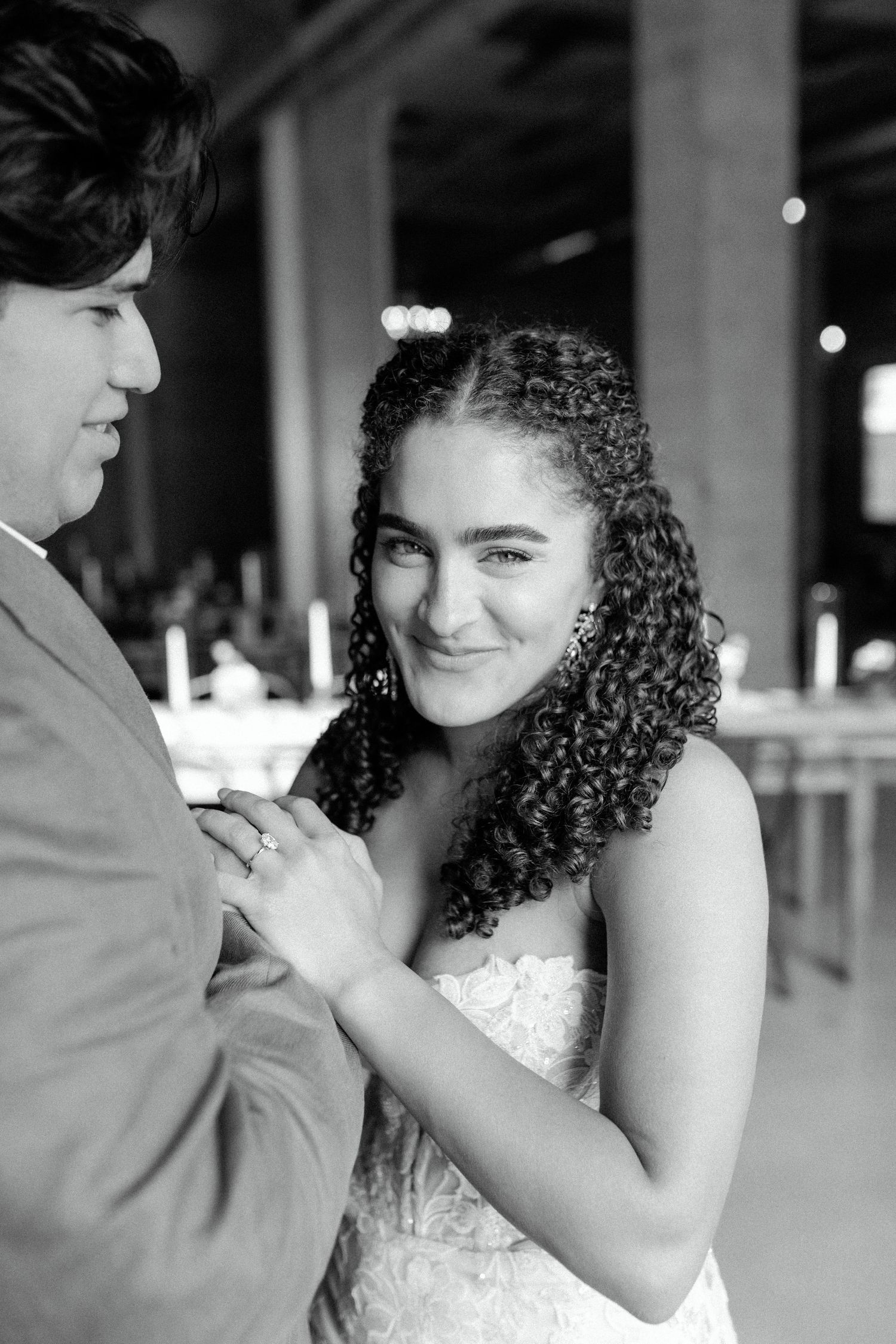 Black and white portrait of newlyweds dancing in modern industrial wedding venue.