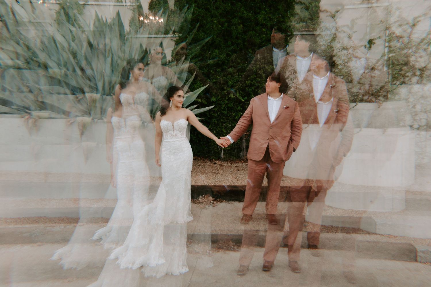 Multiple exposure wedding photo showing dreamy motion blur of couple holding hands outdoors.
