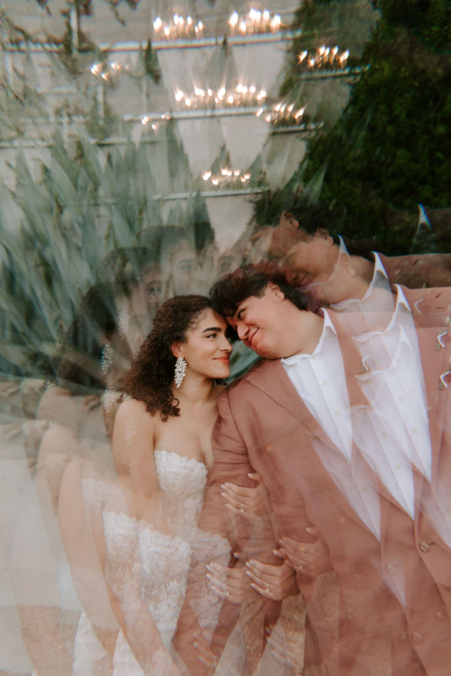 Dreamy multiple exposure portrait of couple with soft lighting and greenery.