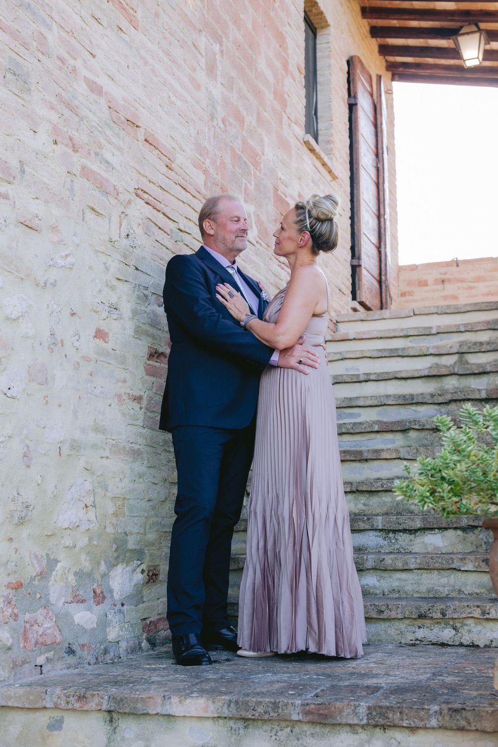 A romantic portrait sequence showing a couple embracing against a rustic stone wall backdrop.