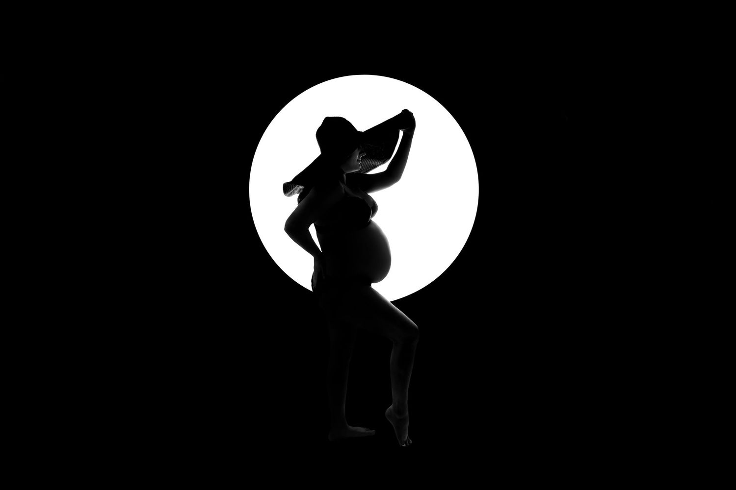Silhouette of a child or small figure looking up at a bright full moon against a dark background.
