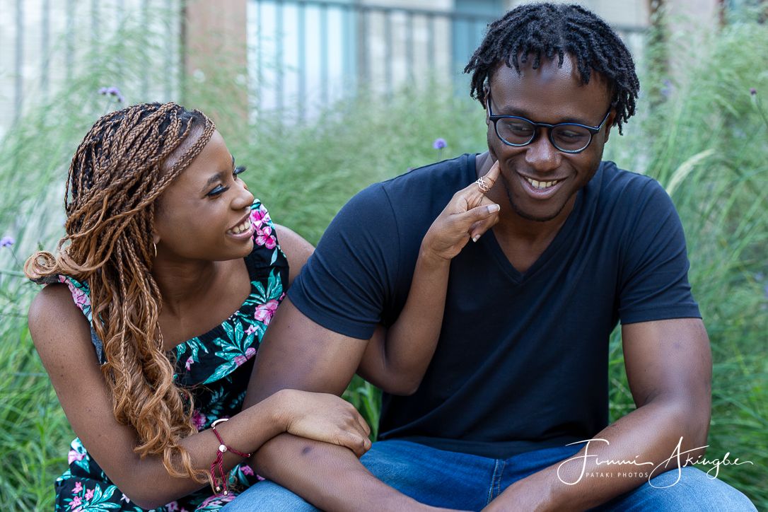 Siblings sharing a tender moment while sitting together outdoors for an informal photoshoot