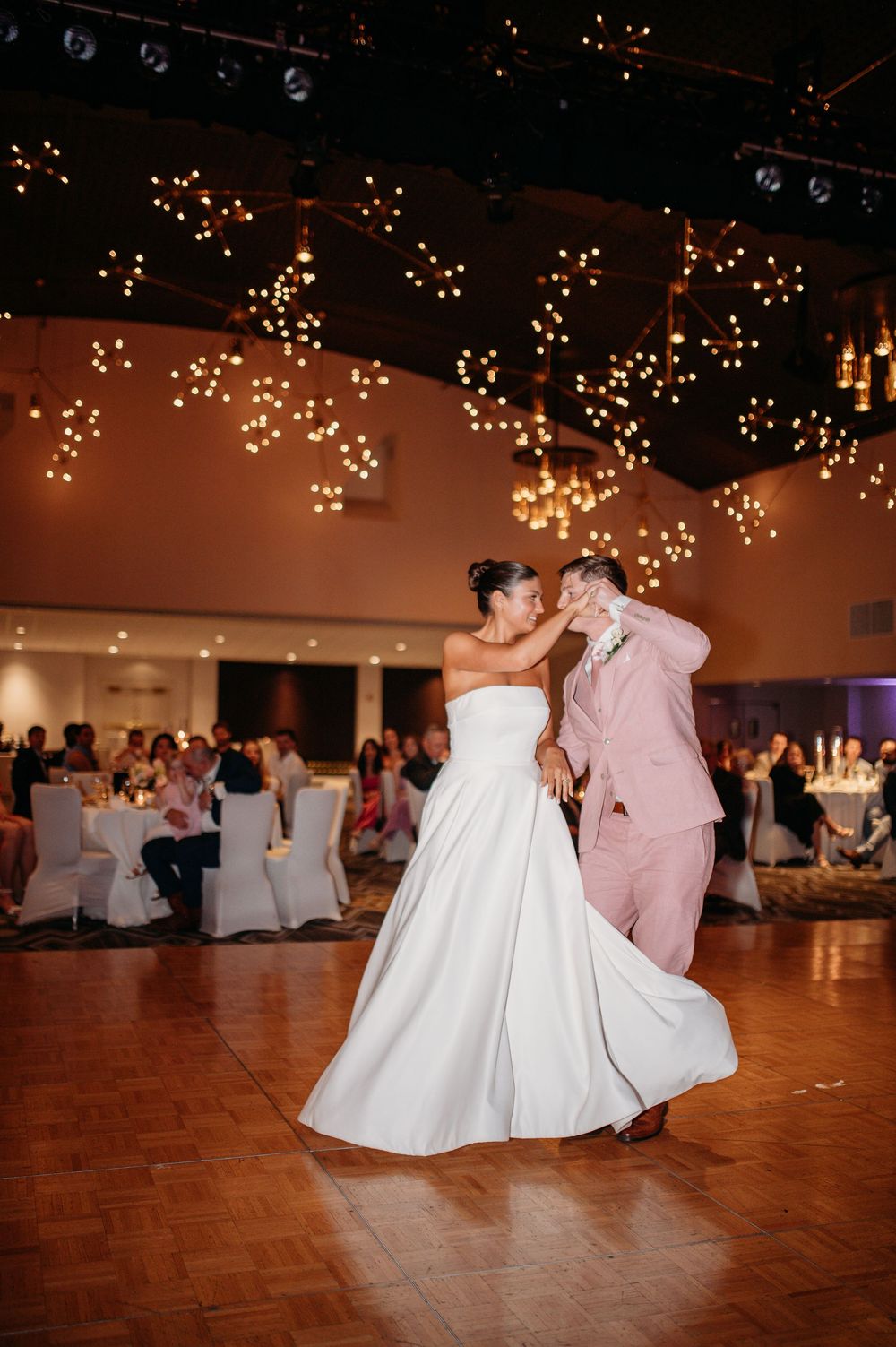 Romantic first dance at wedding reception with twinkle lights decorating the ceiling.
