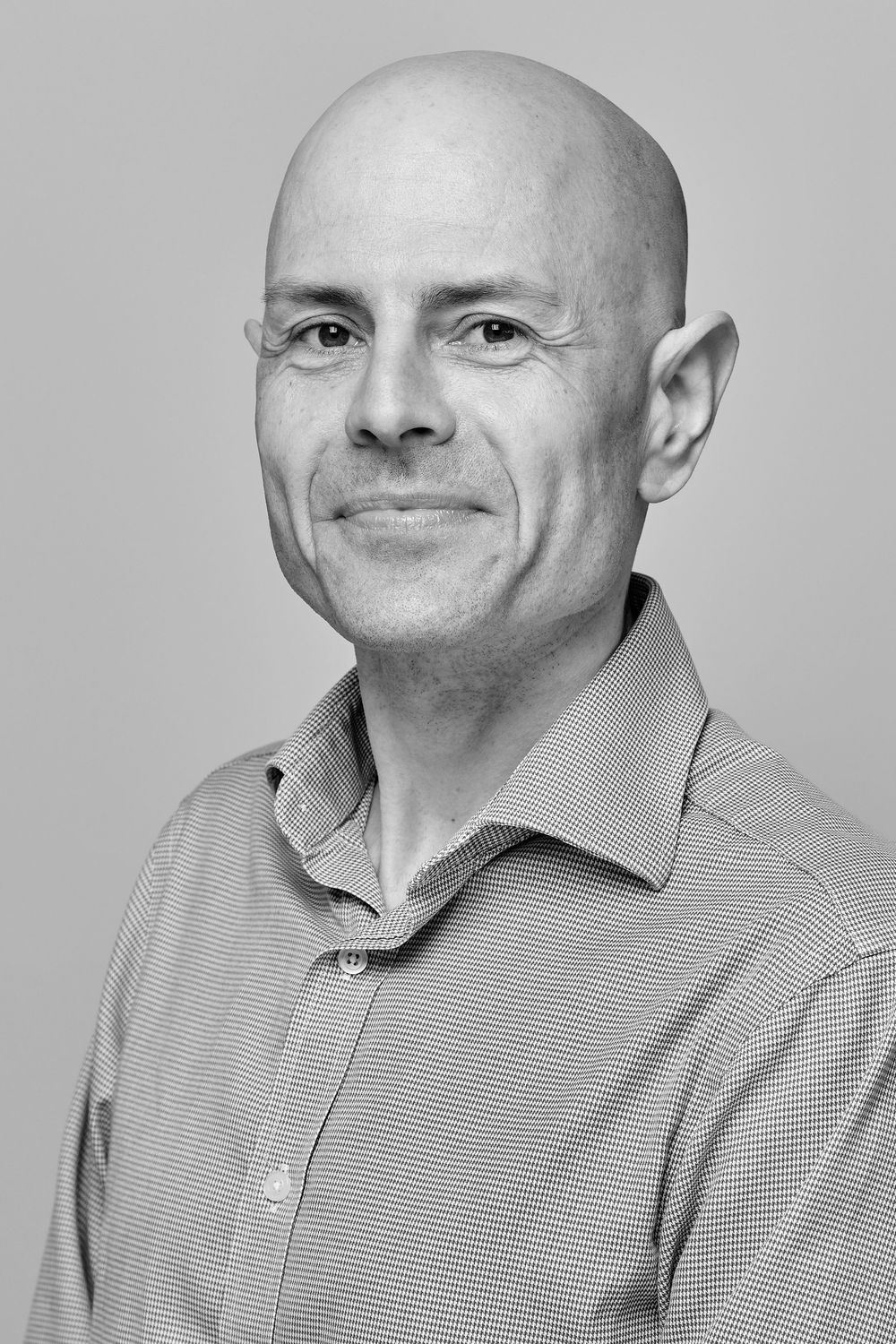 A series of black and white headshot portraits showing different facial expressions against a light background.