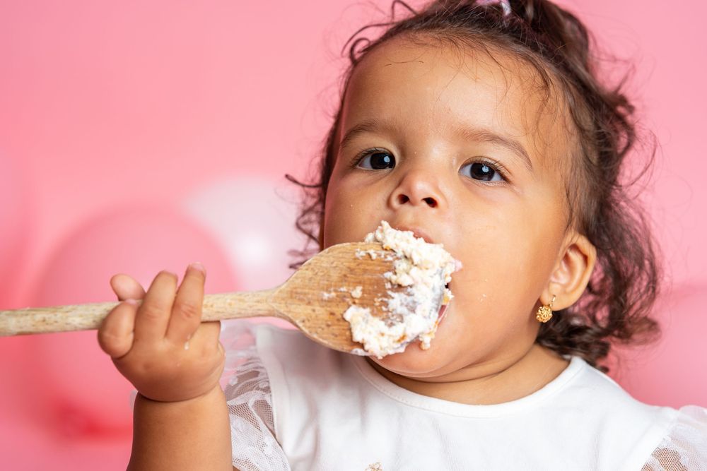 Series of candid cake smash moments showing messy frosting fun against pink background.
