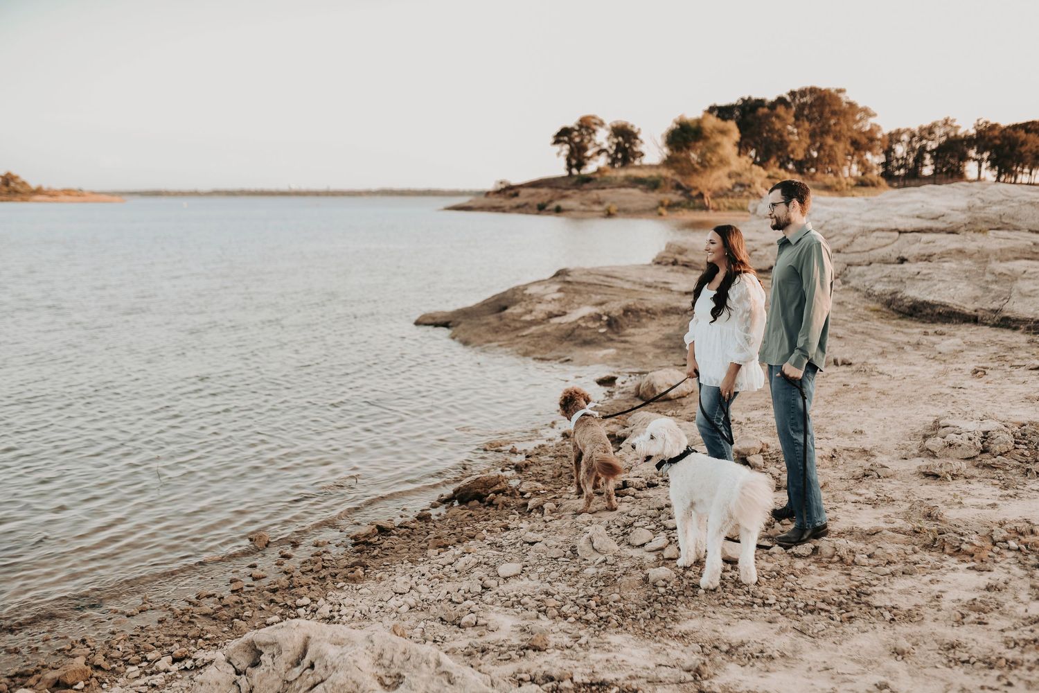 a newly engaged couple walks along lake grapevine with their fur babies for their engagement photos at murrell park