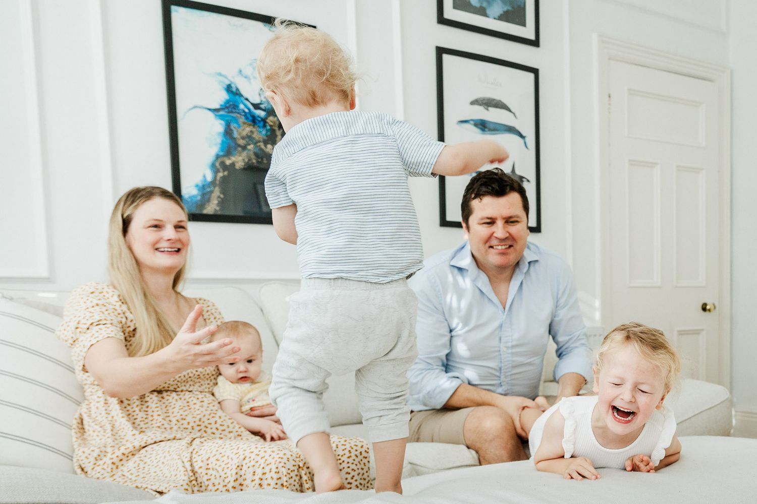 A family laugh and smile as they play at home during their family photoshoot. Bristol family photos by Little Bodhi Photography