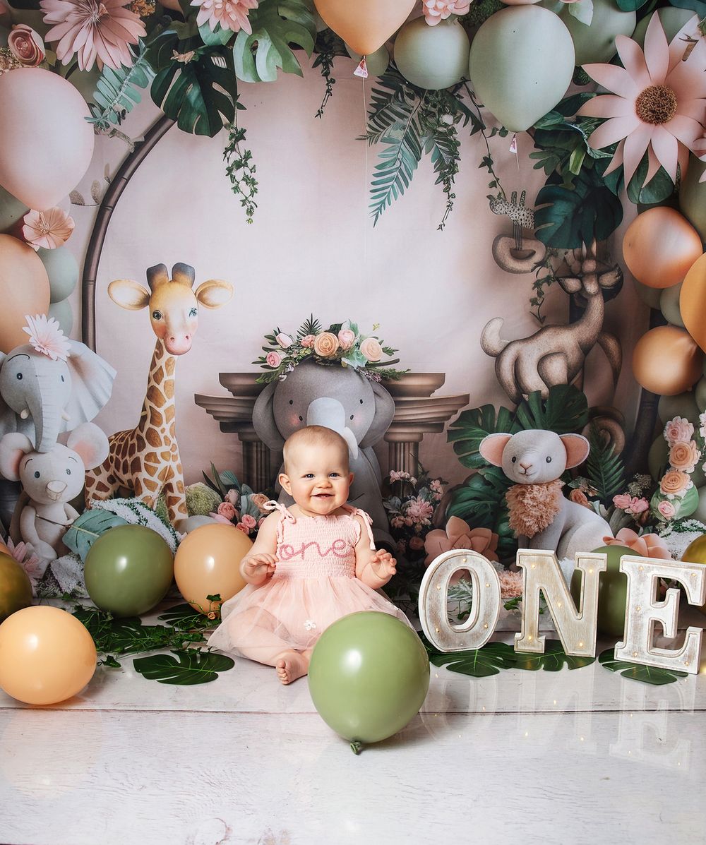 A whimsical first birthday setup in London with balloons, floral decorations, and a 'ONE' letter display in a vintage-inspired setting.