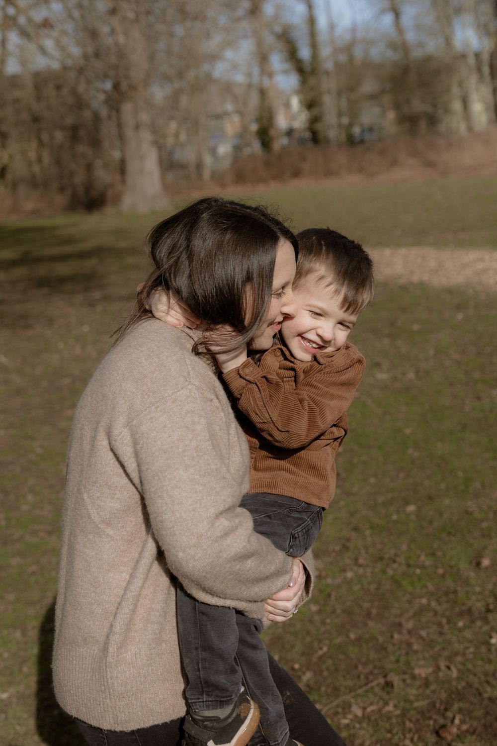 A loving embrace between parent and child enjoying a playful moment outdoors in autumn.