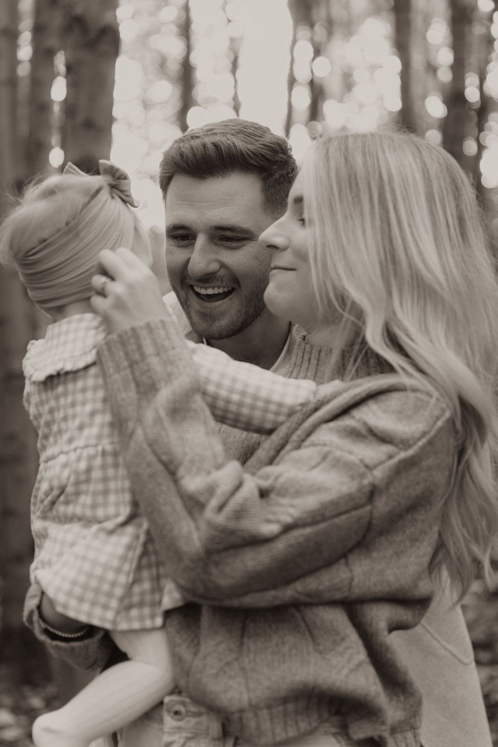 A romantic black and white photo series showing a couple embracing and laughing together outdoors.
