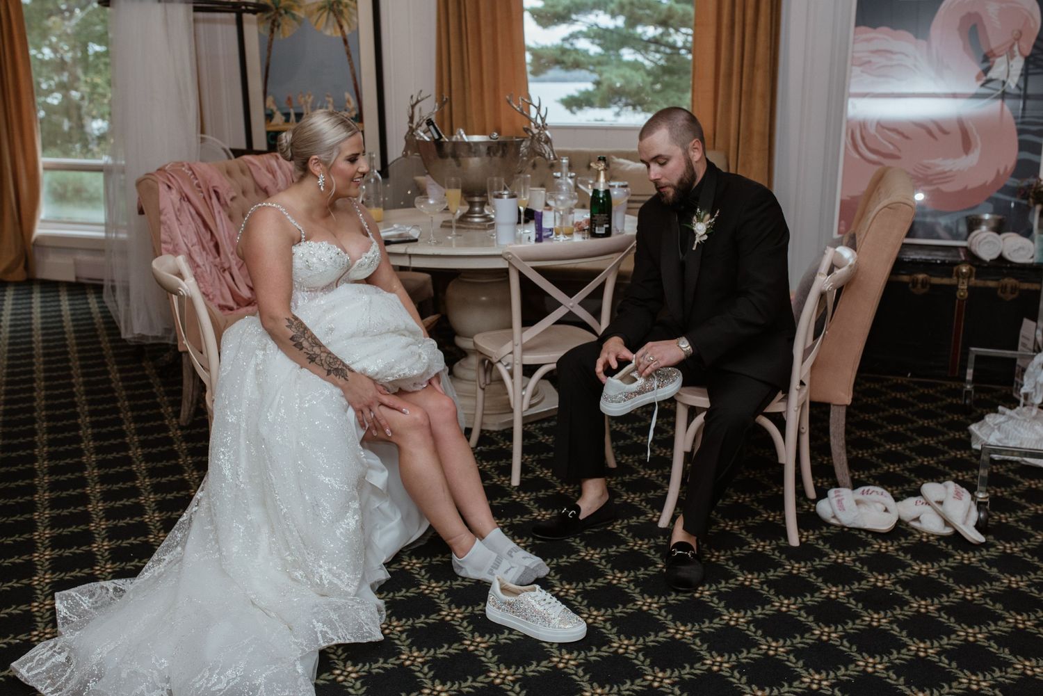 A couple shares a quiet moment while sitting on pink upholstered chairs in a dining room with patterned carpet.